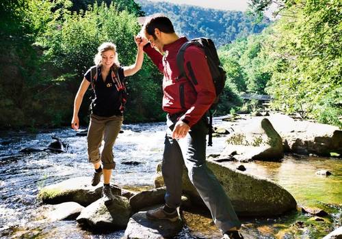 Wanderer beim Überqueren eines Flusses im Harz